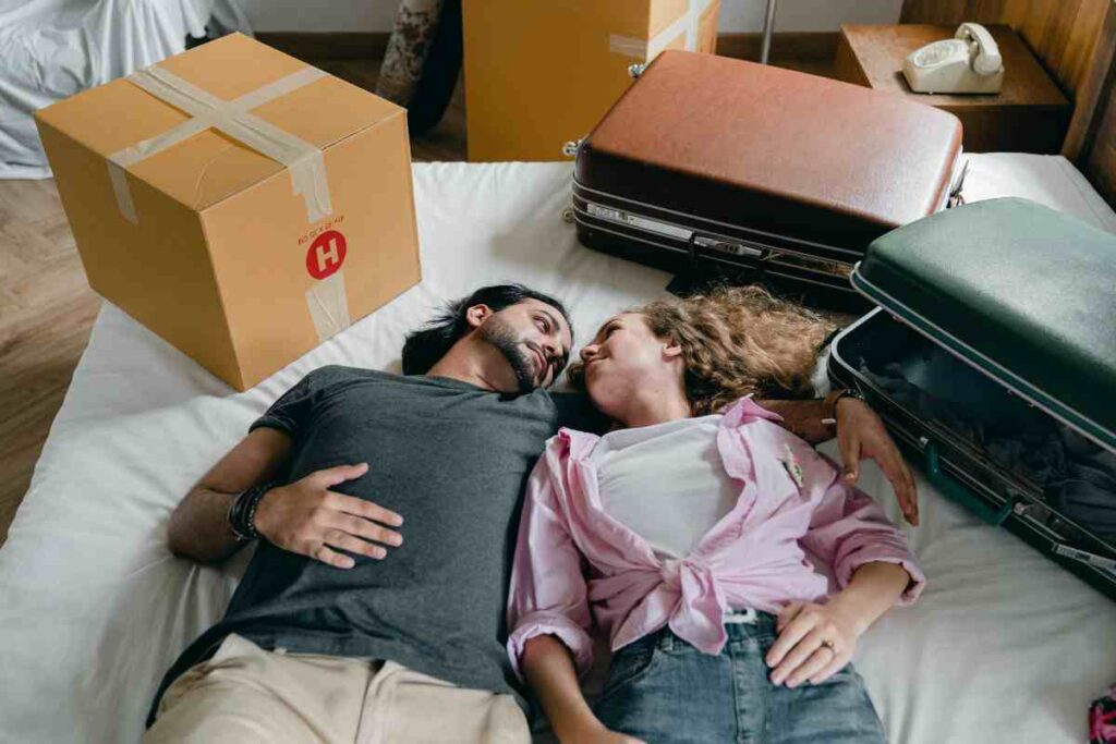 Coppia sul letto con valigie - prestiti.com