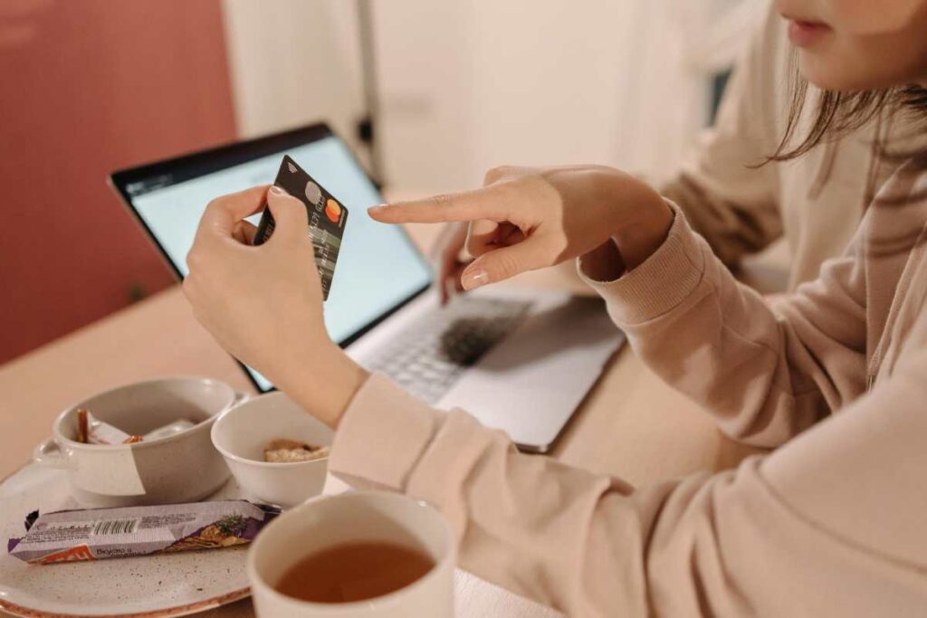 Ragazza che usa la carta di credito per acquisti online - prestiti.com