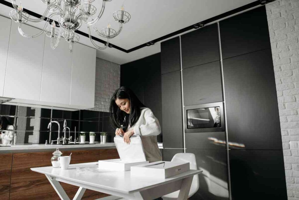 Una donna in cucina che scarta un acquisto - prestiti.com