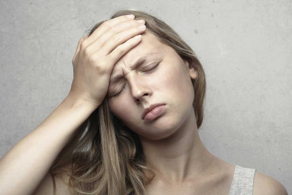 Ragazza addolorata che si tocca la testa - prestiti.com