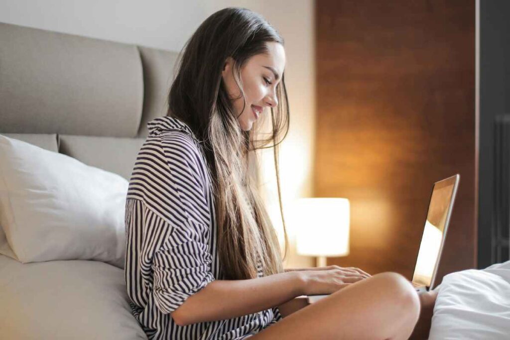 Ragazza al computer sul letto - prestiti.com