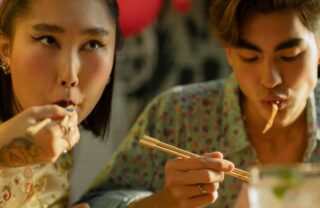 Ragazzi asiatici che mangiano con le bacchette