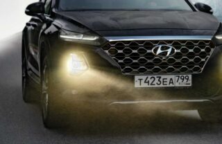 Auto berlina nera con fari accesi
