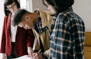 Firma di un contratto: un ragazzo con due ragazze