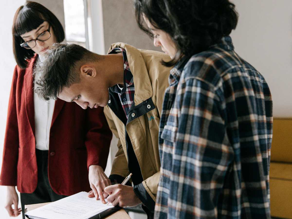 Firma di un contratto: un ragazzo con due ragazze